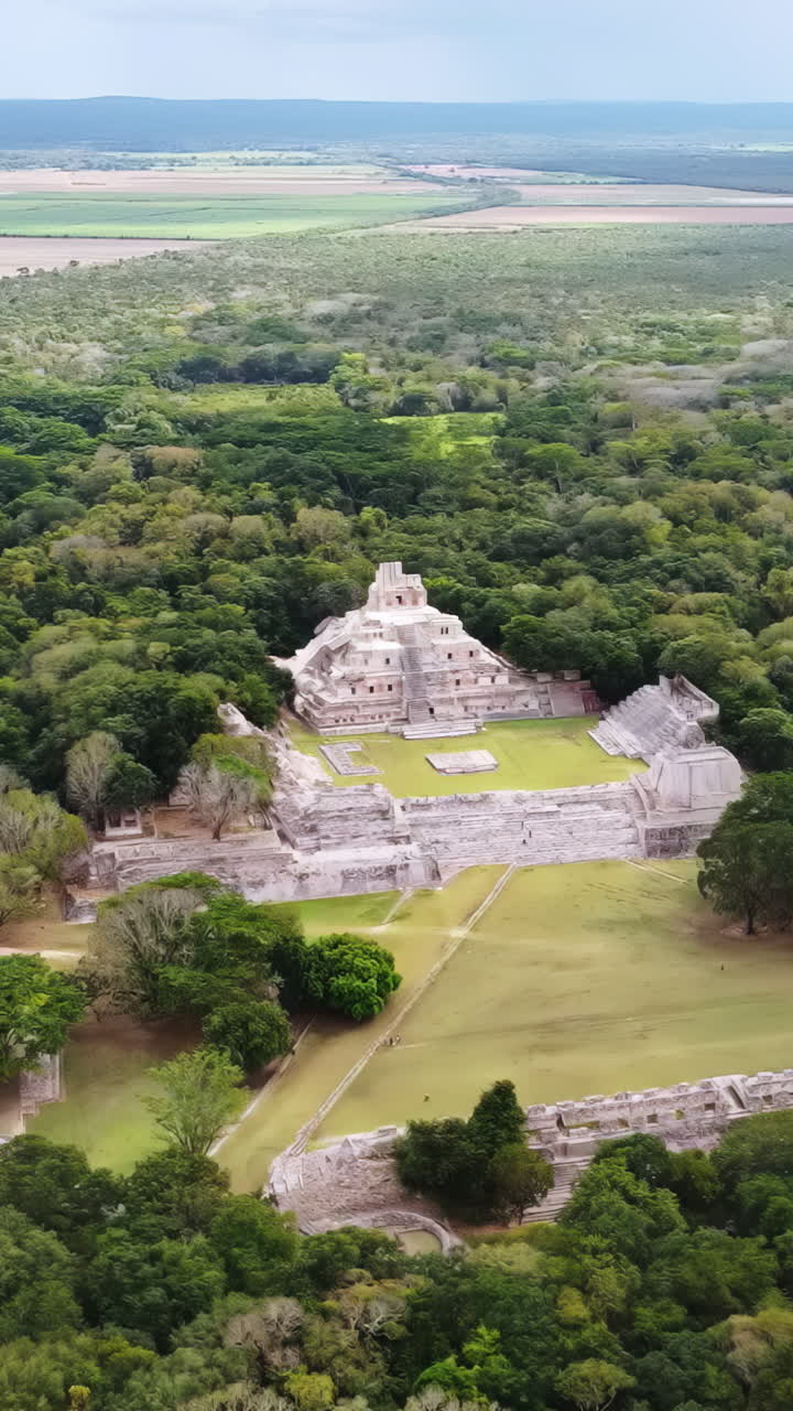 Vista aerea con drone della piramide Maya di Edzná che si erge sopra una fitta foresta tropicale a Campeche, Messico, rivelando antiche rovine mesoamericane circondate da un paesaggio della giungla. Verticale