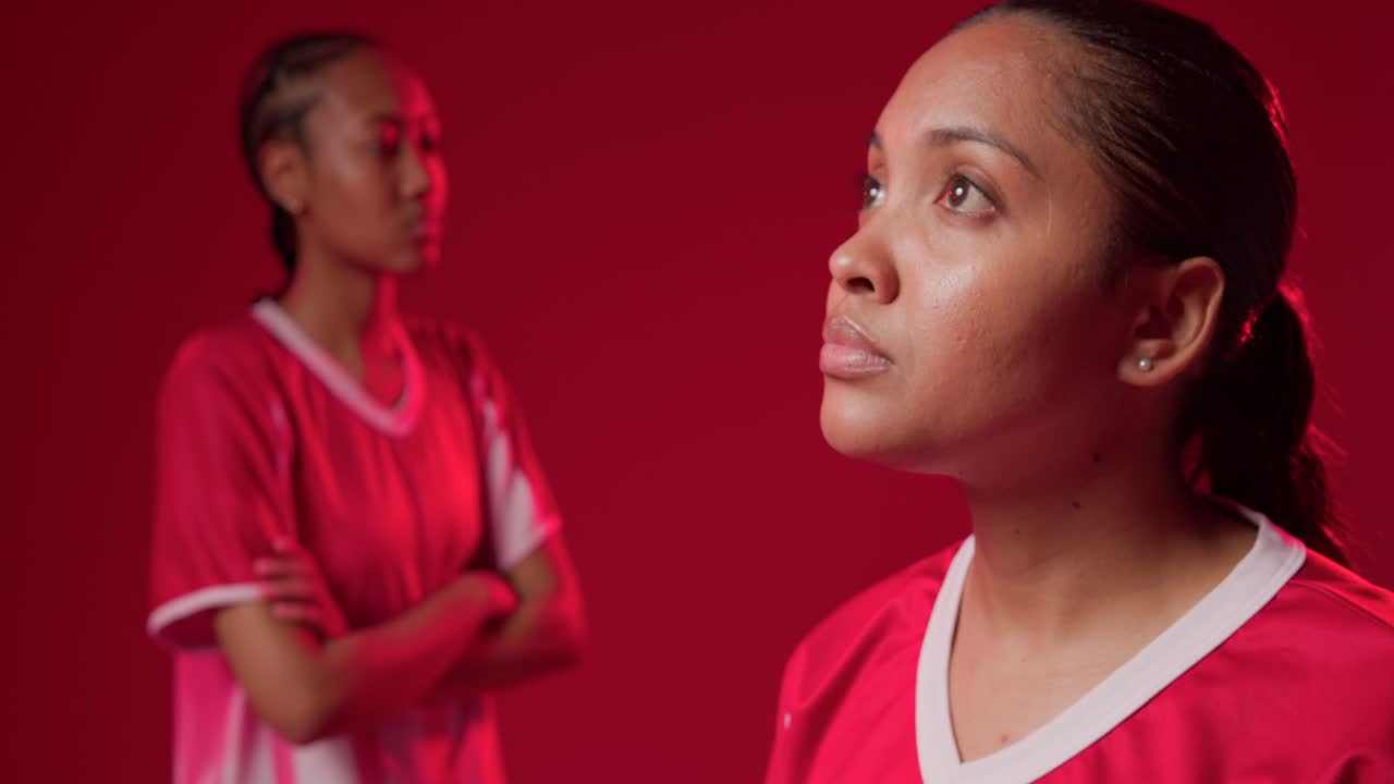 Donne afroamericane in studio, la telecamera si concentra sulla donna a destra che si avvicina per un ritratto con maglie rosse