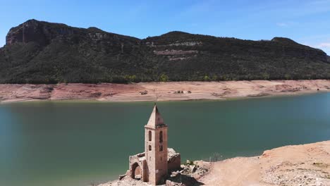 Aerial-shot-over-a-ruined-church-by-the-reservoir