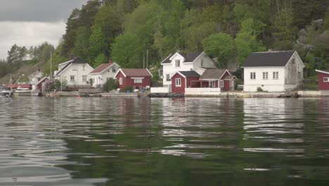 typical wooden homes on idyllic lakeshore in countryside of norway