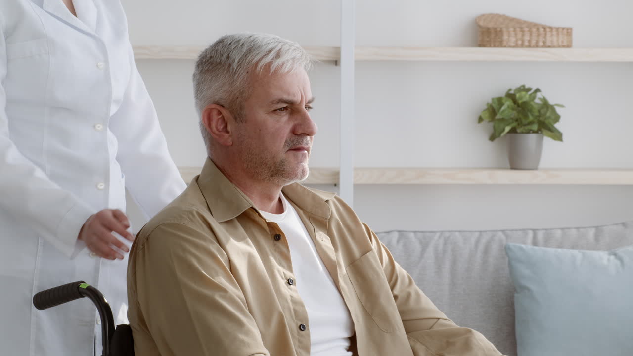 Doctor comforting senior patient in a wheelchair