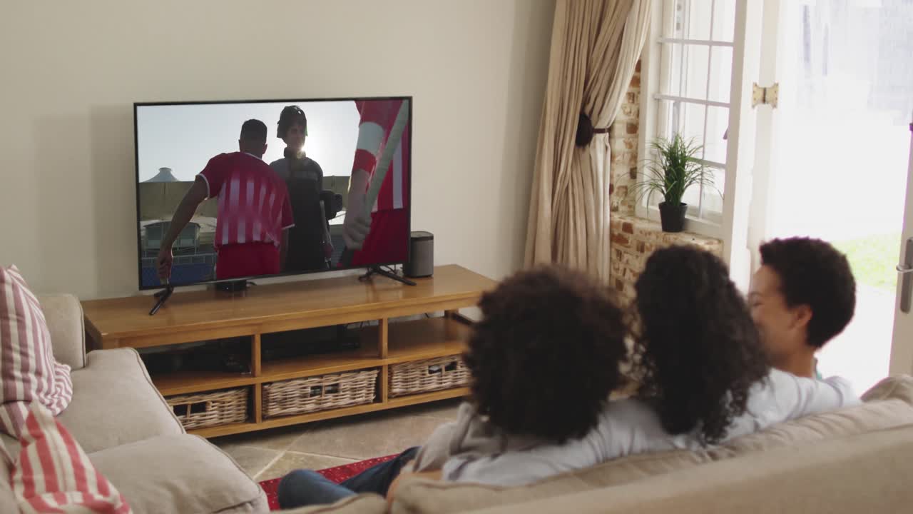 Famiglia felice seduta a casa insieme che guarda una partita di hockey in TV