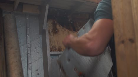 young man removing interior lifting eye plate on seaplane tender wooden boat