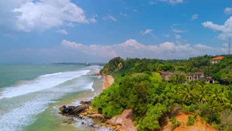 a breathtaking aerial drone shot of sk town surf beach in weligama, sri lanka, where lush jungle meets the ocean.