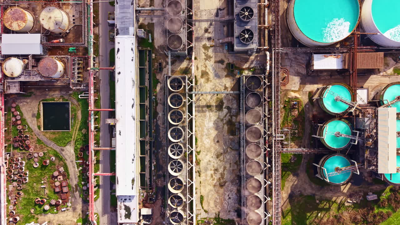 Overview of an industrial site showing storage tanks, processing equipment, and surrounding areas in a manufacturing facility located near a road
