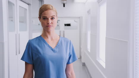 portrait of female doctor wearing scrubs in hospital corridor