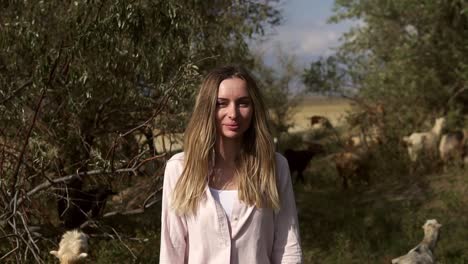 Woman-stroking-two-small-goats-outdoors-during-her-road-trip