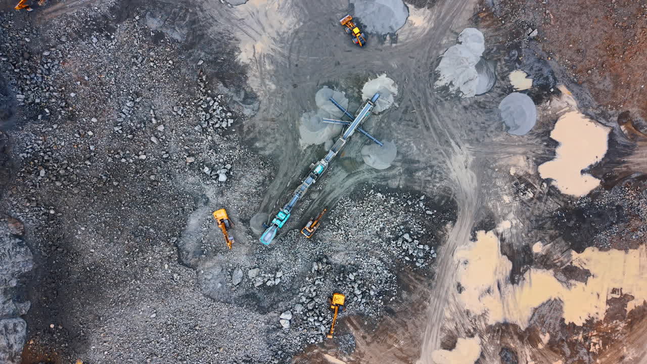 Active construction site with machines. Heavy machinery is working on a construction site with large rocks and piles of materials