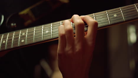 guitarist hand playing guitar in studio. unrecognizable man rehearsing indoor.