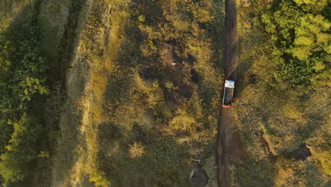 steady drone shot of a trick driving - dirt road