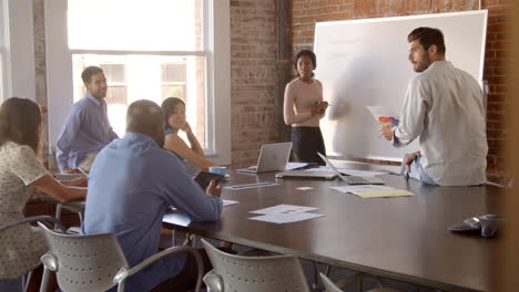 businesswoman at whiteboard in office giving presentation