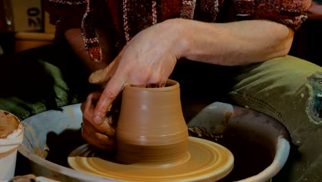 professional male potter working with clay on potter's wheel