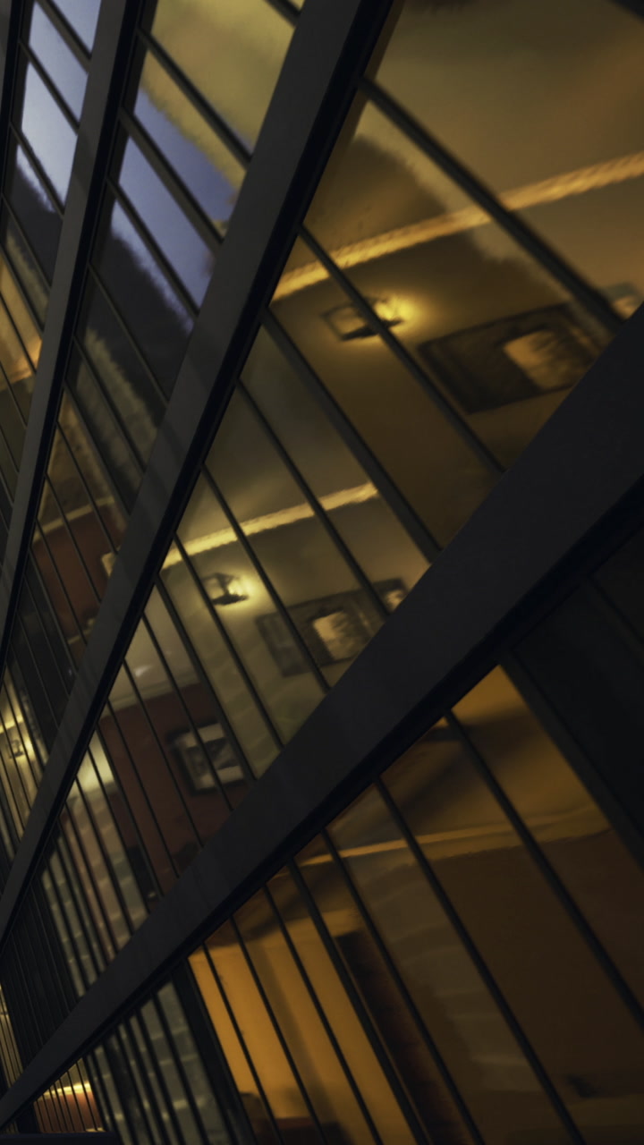 Reflection of lights on glass building at dusk in urban area