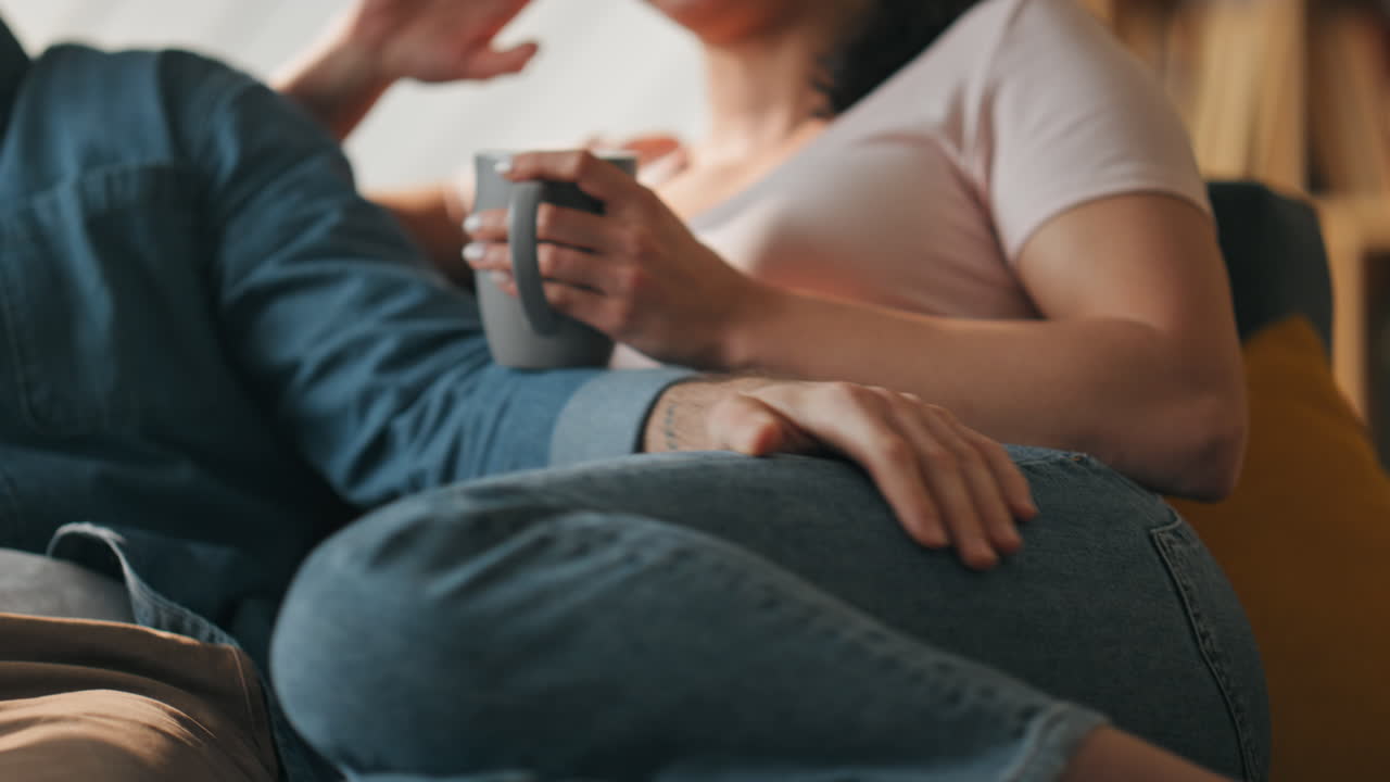 사랑하는 커플이 차 한 잔과 함께 소파에 누워서 이야기하고 있습니다. 가족이 함께하는 시간