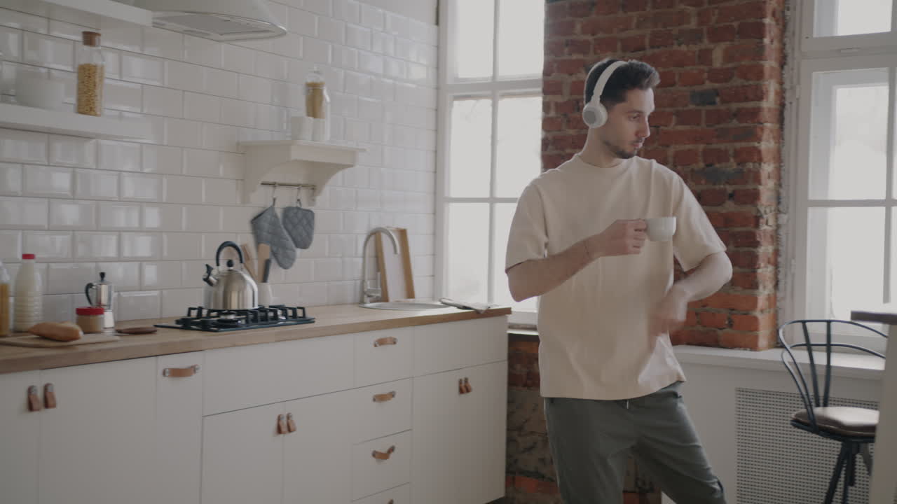 Man Dancing in Kitchen while Listening to Music
