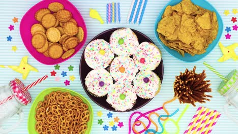 decoración de la fiesta moviéndose alrededor de pasteles de taza de cumpleaños con crema blanca - stop motion