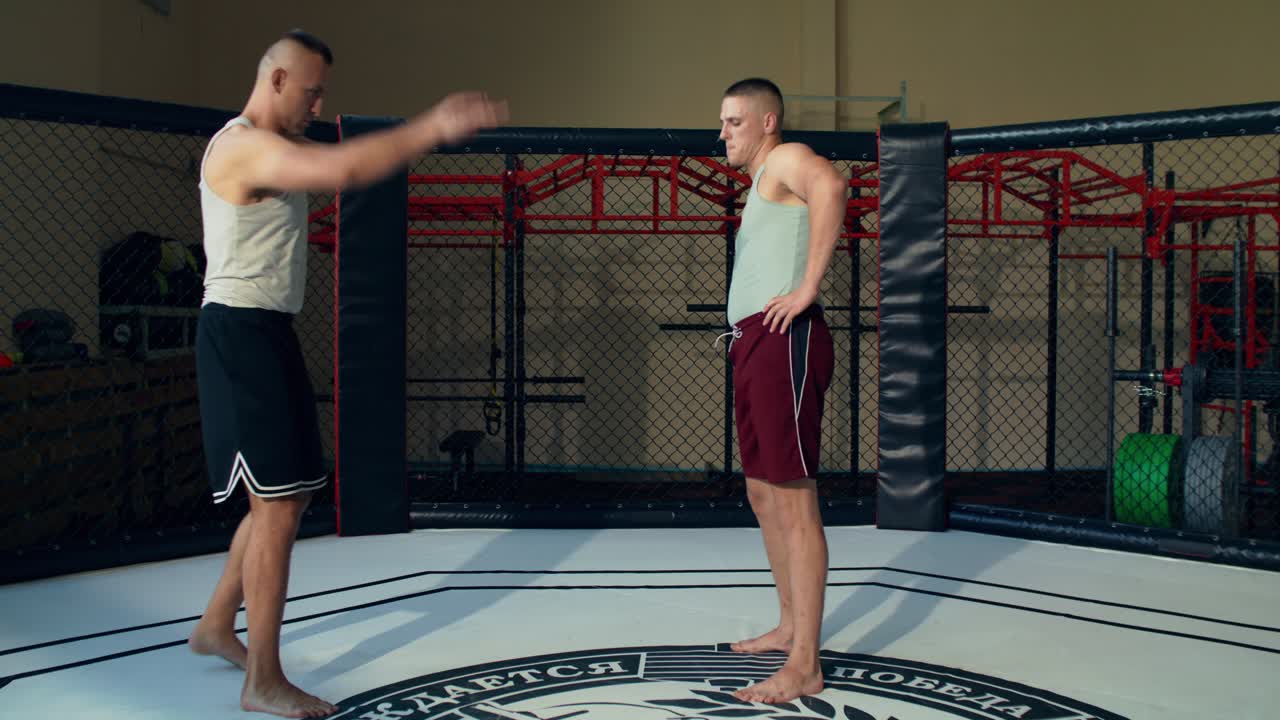 To mænd, der træner i et MMA-bur