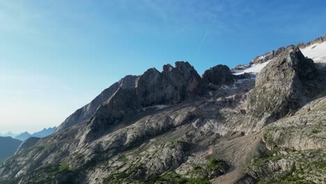 dolomite peaks under clear blue skies, with patches of snow on rocky slopes