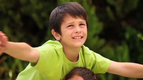 Father-with-his-son-on-his-shoulders-playing-in-the-garden