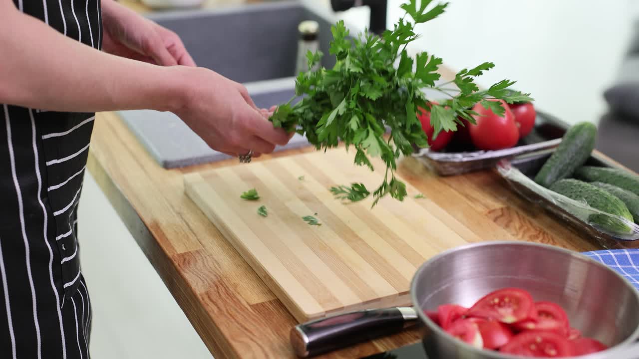 Hands preparing fresh parsley in a kitchen