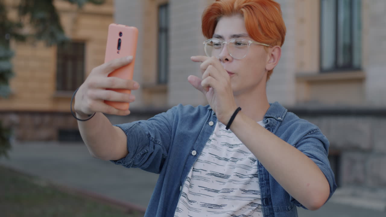 Teenage boy taking a selfie video call outdoors