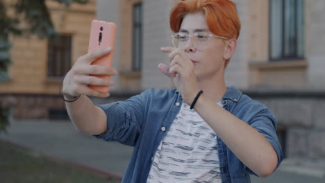 teenage boy taking a selfie video call outdoors