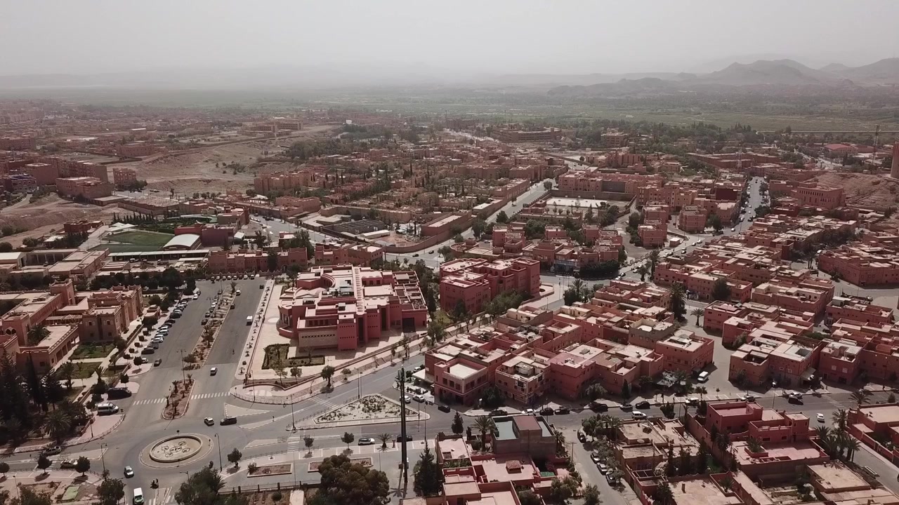 Veduta aerea con drone del centro di Ouarzazate, che evidenzia moderni spazi pubblici, quartieri turistici e il fascino culturale della porta del Marocco verso il Sahara.