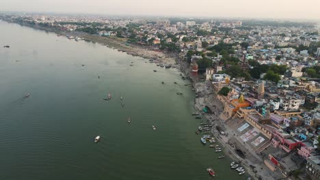 drone shot of banaras at sunset, with the ganga river reflecting the rich colors of the evening sky.