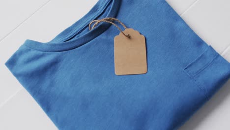 video de una capa plana de camiseta azul con etiqueta y espacio de copia sobre fondo blanco