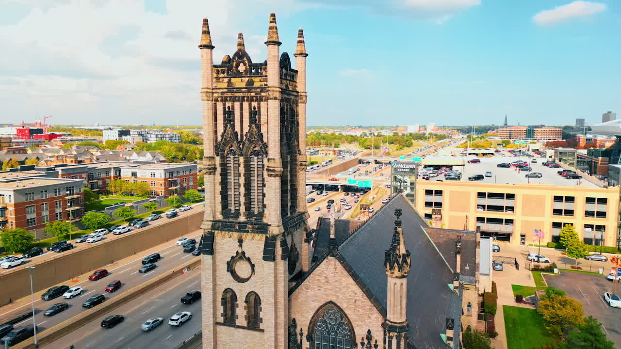 Detroit, USA, 28 July 2025: Stunning beauty of the tower at St. John's Episcopal Church in Detroit, Michigan, USA. Aerial view on the roads with heavy traffic, parking lot at the building roof and stadium
