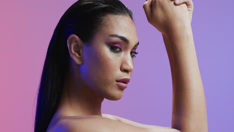 biracial woman with black hair and make up looking at camera, copy space, slow motion