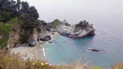 Beim-Schwenken-Sind-Die-Wasserfälle-Von-Mcway-Zu-Sehen,-Die-Entlang-Der-Küste-Von-Big-Sur-In-Die-Bucht-Stürzen