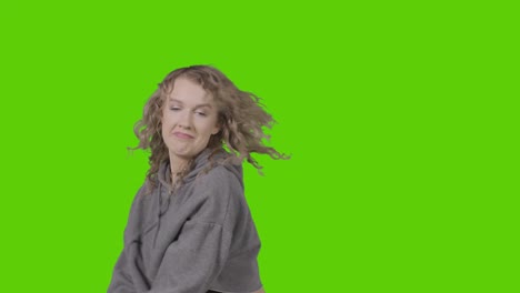 studio shot of young woman having fun dancing against green screen 16