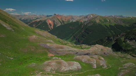 Antena-Zumbido-Cinematográfico-Hielo-Lago-Cuenca-Sendero-Caminata-Silverton-Colorado-Soñador-Celestial-Montaña-Rocosa-Escena-Lozano-Verde-Flor-Silvestre-Verano-Nieve-Derritiéndose-Picos-Rocosos-Avance-Movimiento