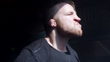 man working out intensely in a dark environment