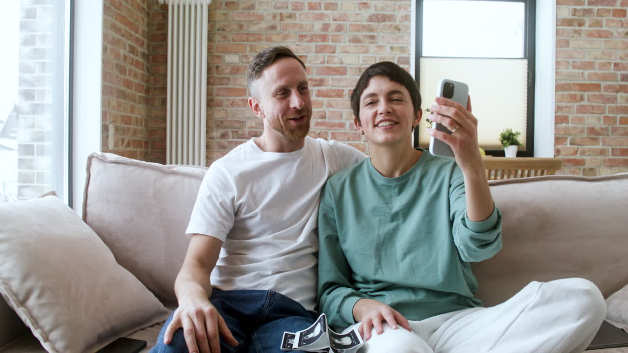Par har videosamtale i sofaen