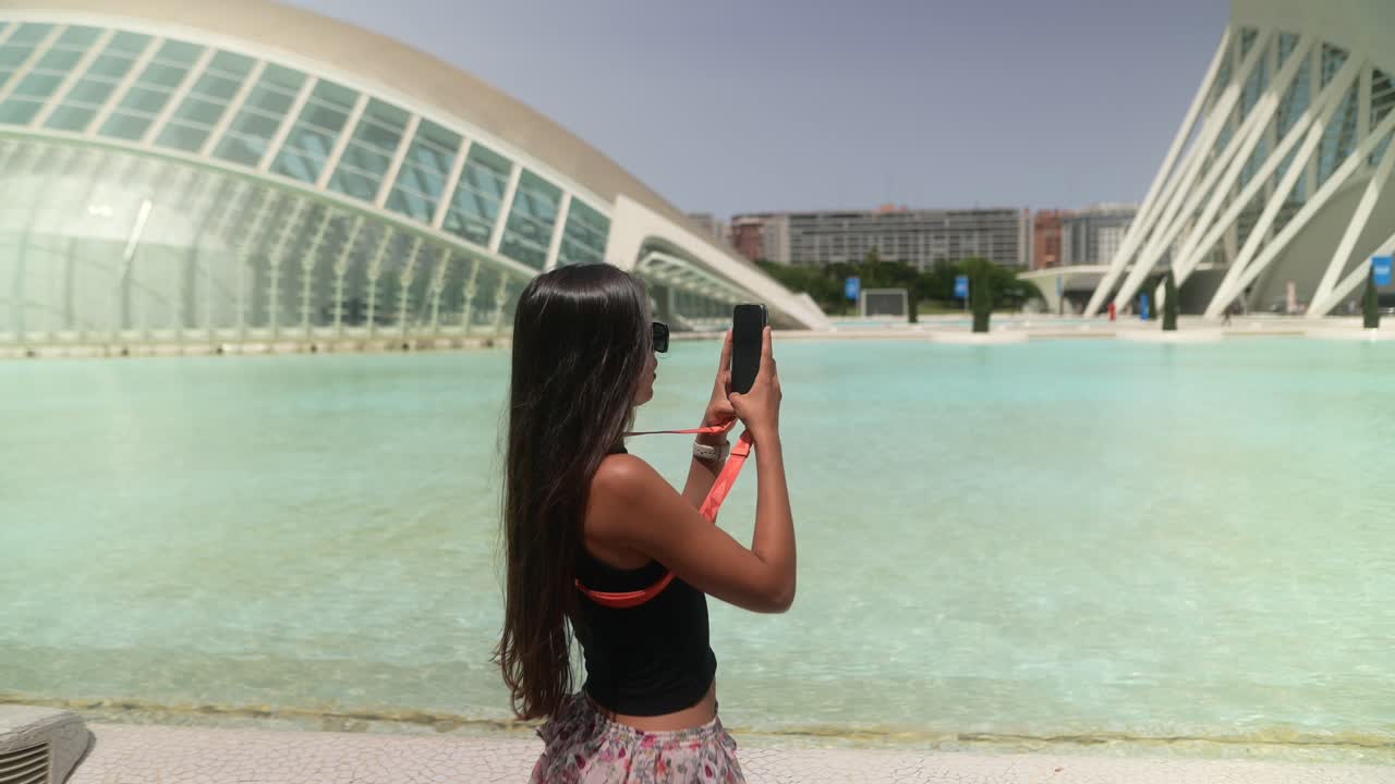 mujer tomando una foto frente a la arquitectura moderna