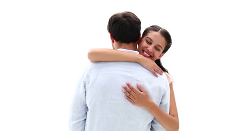una atractiva pareja de jóvenes abrazándose y sonriendo a la cámara