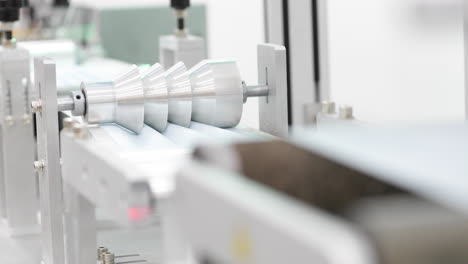 modern machinery on process of putting pleats on fabric strips of protective mask