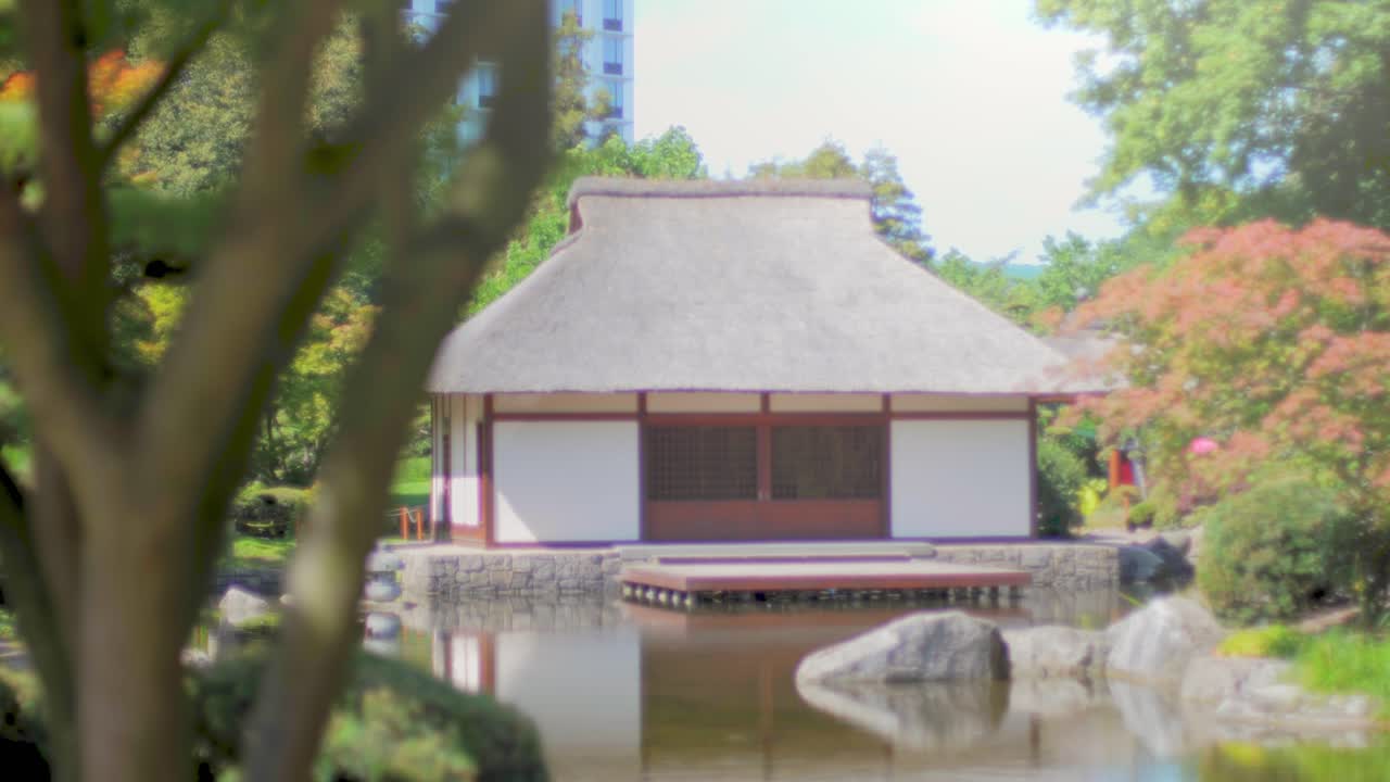 casa de té japonesa además de un estanque con reflejos en el agua