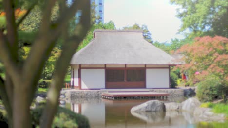 japanese teahouse besides a pond with reflections in the water