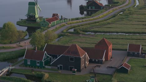 Tilt-up-shot-of-popular-dutch-windmills-Zaanse-schans-tourist-destination,-aerial