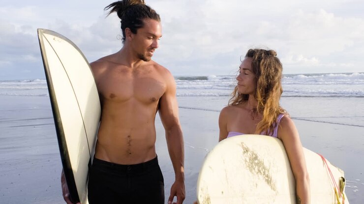 Young couple with surfboards