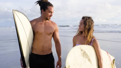 young couple with surfboards