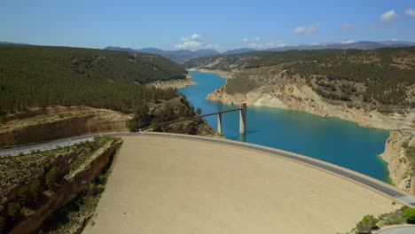 Drone-view-of-dam-with-road-closing-reservoir