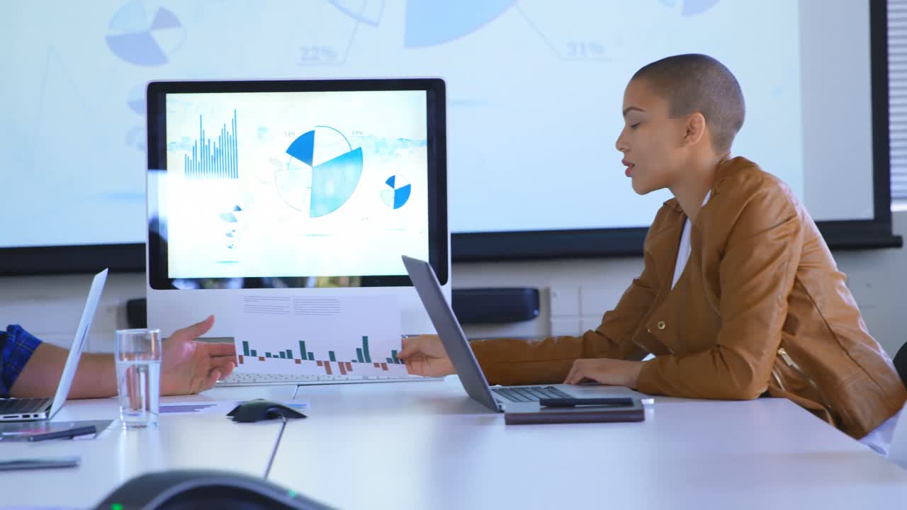 Side view of young caucasian business colleagues discussing over graph documents in modern office 4k