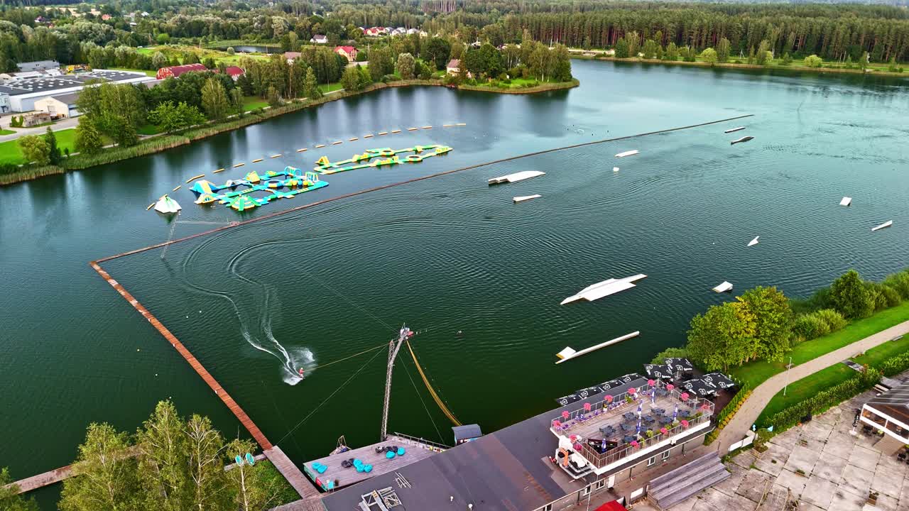 Aerial view of wakeboarders riding on water cable park obstacle track