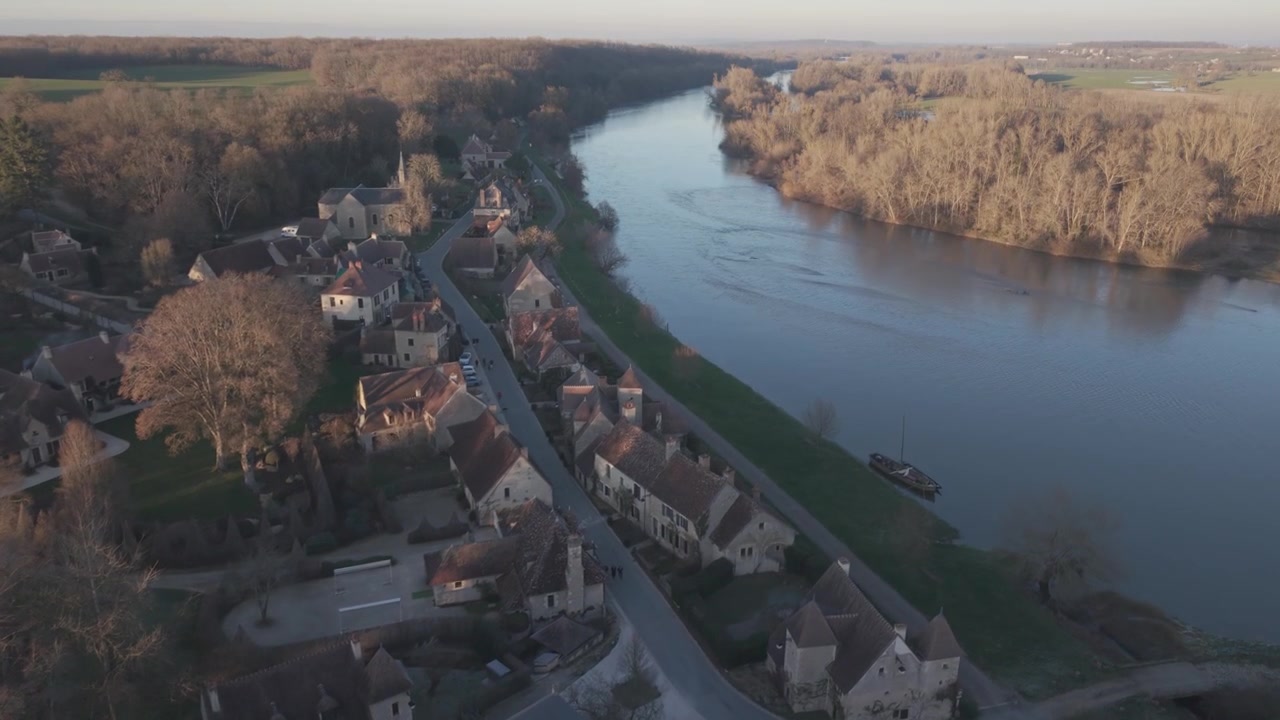 Una vista aerea mostra una fila di case lungo il fiume e una strada alberata accanto al fiume Loira in Francia.