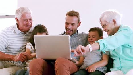 Linda-Familia-Usando-Computadora-Portátil-En-El-Sofá