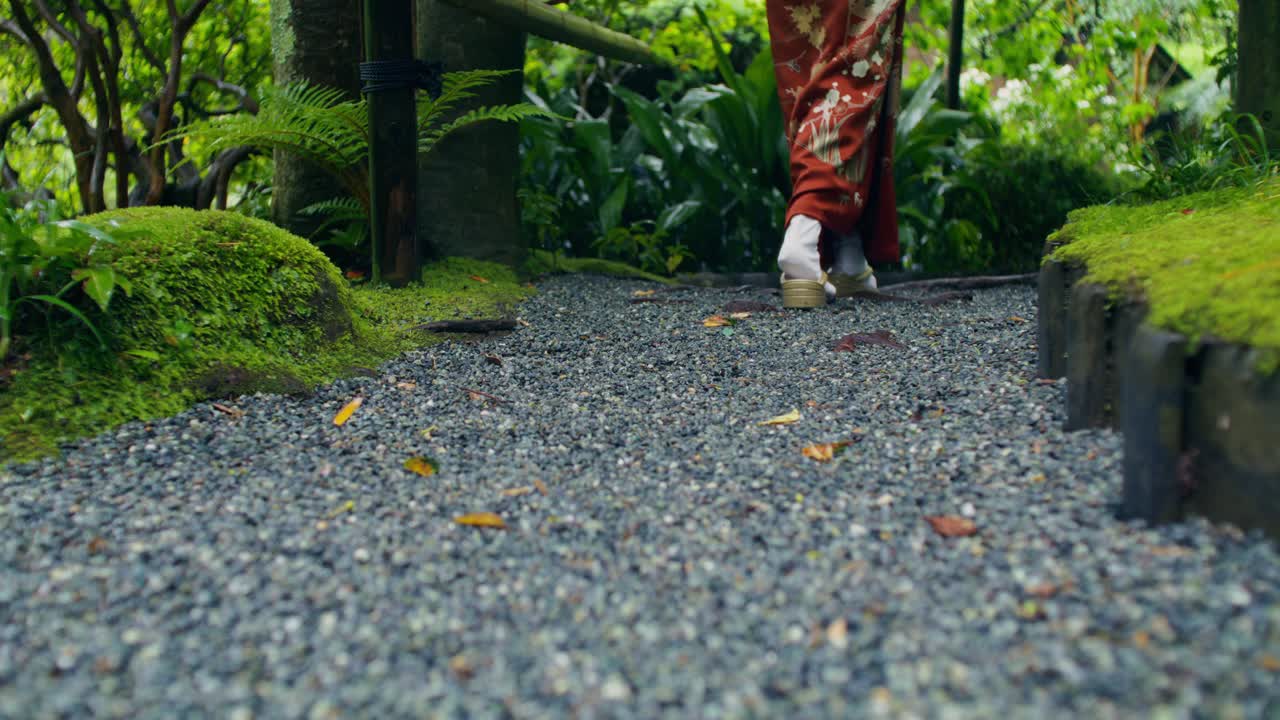 키모노 를 입은 여자 가 일본 정원 을 걸어가고 있다